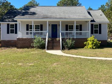 White house with blue door and front porch.