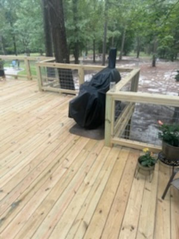 Wooden deck with a covered grill and potted plants.