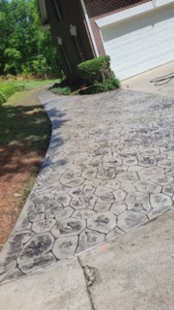 Stamped concrete driveway with a hexagonal pattern near a garage.