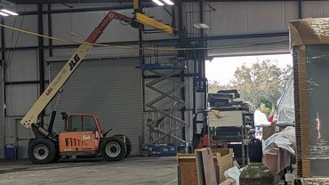 Indoor construction site with lift and scaffolding.