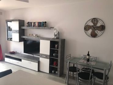 Sala de estar moderna con muebles en tonos grises y blancos.