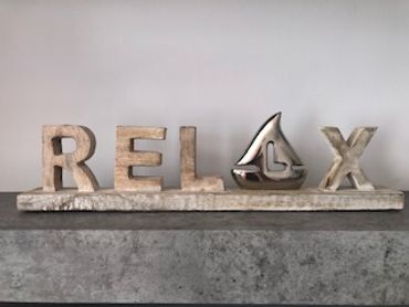 Decoración que dice RELAX con letras y símbolo de vela.