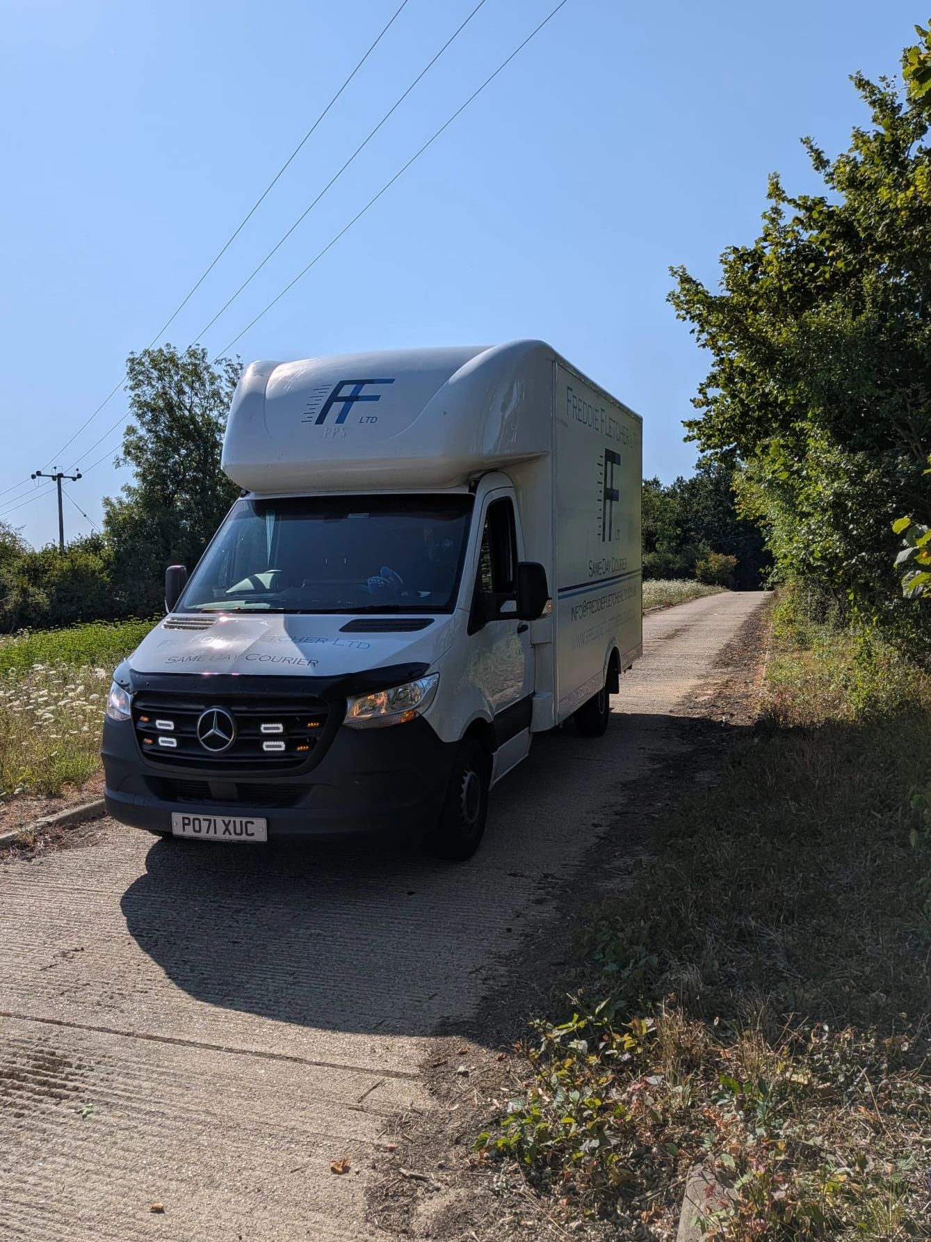 White delivery van parked on a country road.