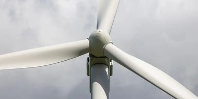 Close-up of a wind turbine against a cloudy sky.