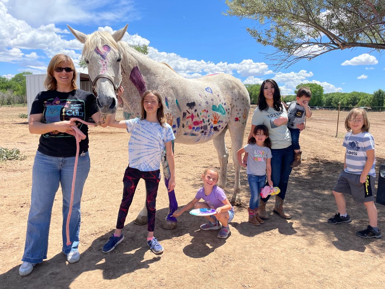 Family painting a horse.
