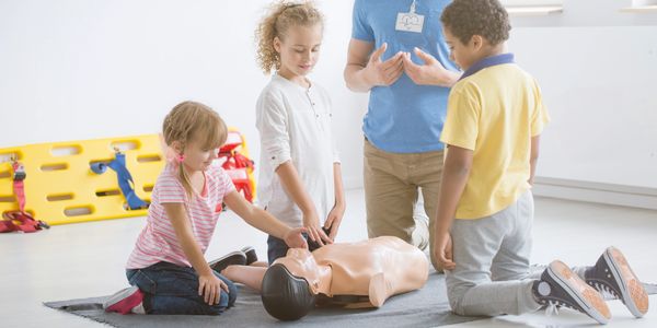 CPR instructor teaching 3 children around a CPR manikin.
Image: By bialasiewicz @Envato 
