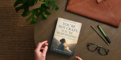 Book titled 'You're Not Crazy, You're Responding' on a wooden table.