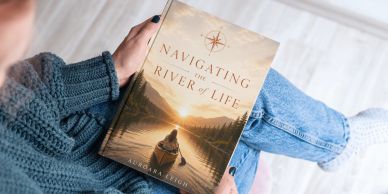 Person holding the book "Navigating the River of Life" by Margaret Brown.