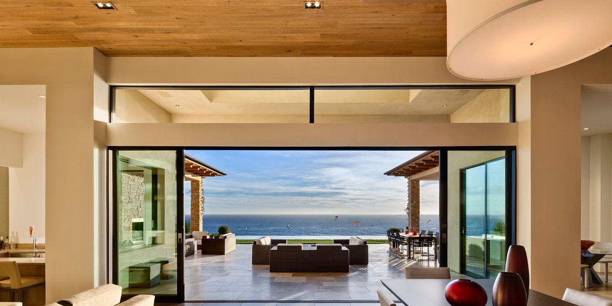 Luxury open-concept home with panoramic ocean view, retractable glass doors, and indoor-outdoor living design