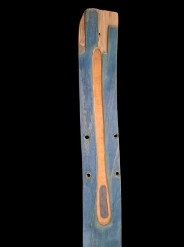 Wooden mold with a carved shape and paint residue.