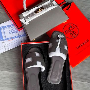 Hermès sandals and a matching handbag on branded orange boxes.