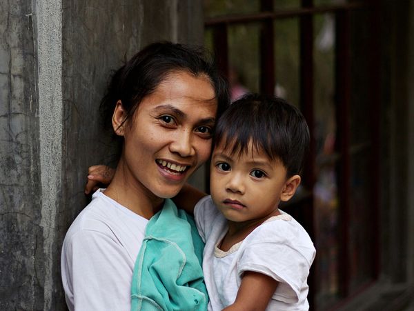 Smiling woman holding a young child.