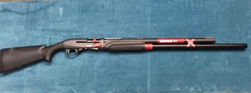 Black shotgun with red accents on a blue surface.