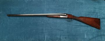 A classic double-barrel shotgun with wooden stock against a blue background.