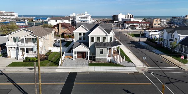Modern two-story house near the coast with a driveway and front porch.
