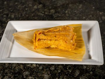 Traditional Cuban tamal made with seasoned corn dough and savory pork, wrapped and cooked to perfect
