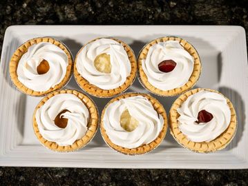 Mini pastry shells filled with sweet cream or fruit filling.