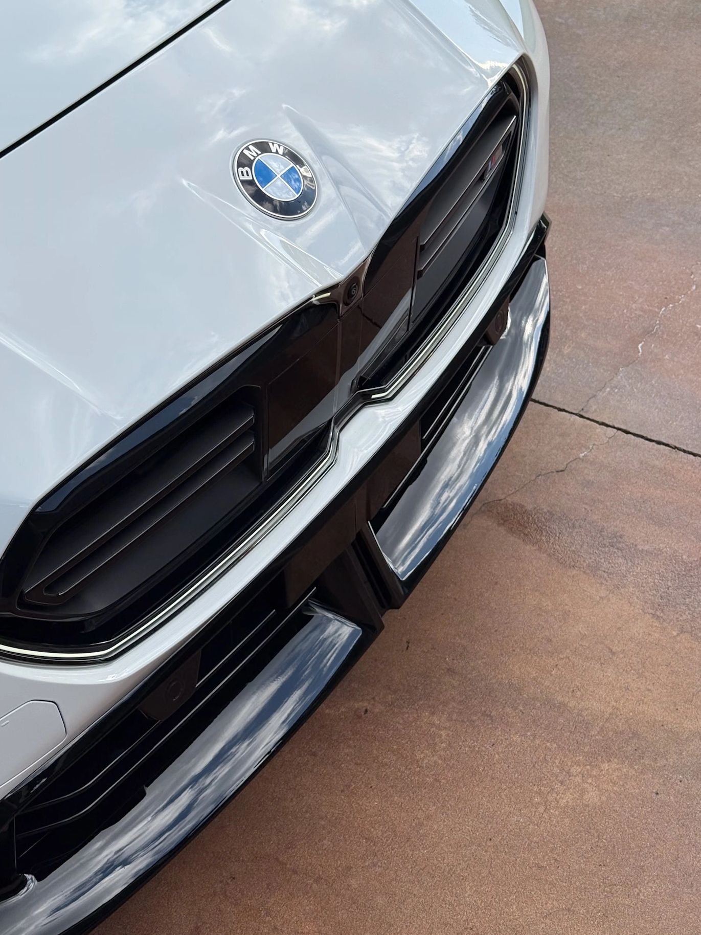 Close-up of BMW car front with iconic logo.