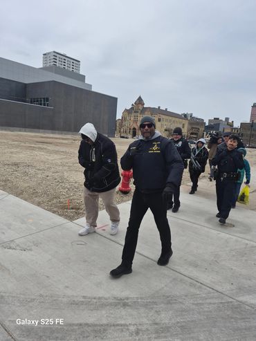 A group of people walking outdoors on a cloudy day in an urban area.