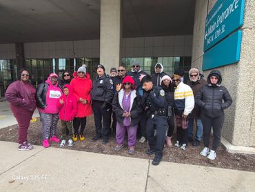 Group of people, some in police uniforms, posing outside a building.