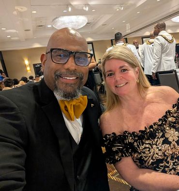 A stylish couple dressed formally at a banquet event.