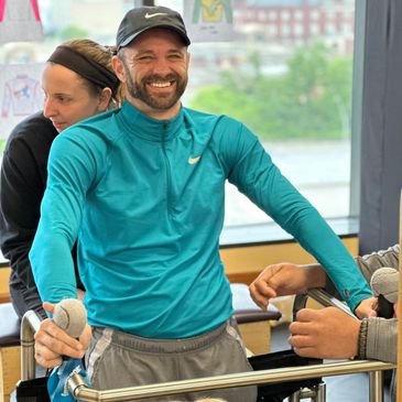 A quadriplegic using a standing frame during physical therapy using electrical stimulation