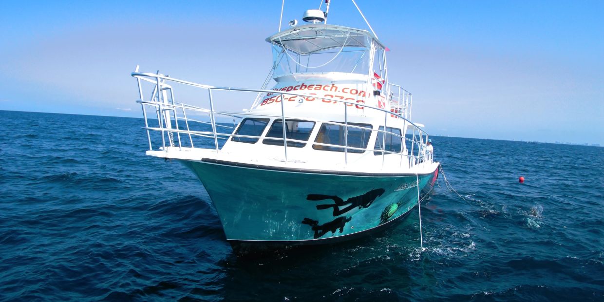 White boat on blue ocean water under clear sky.