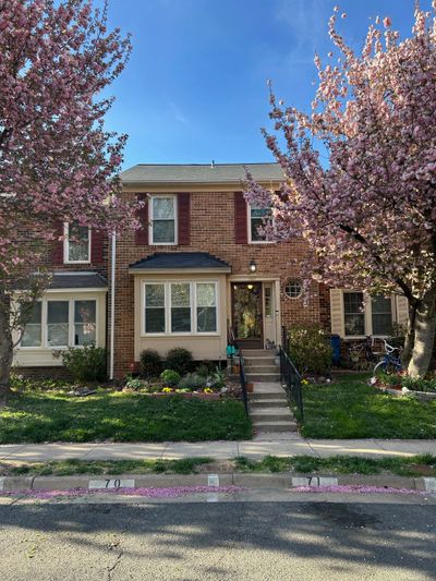 Photo of 7343 Stream Way, Springfield, VA -  a colonial townhouse flanked by 2 pink blooming cherry 