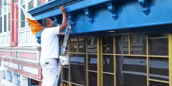 painter painting a building blue