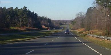 two lane road or highway, not too much traffic, trees line both sides of the road