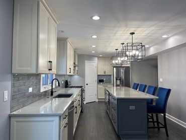 Kitchen remodel with white cabinet and island seating 