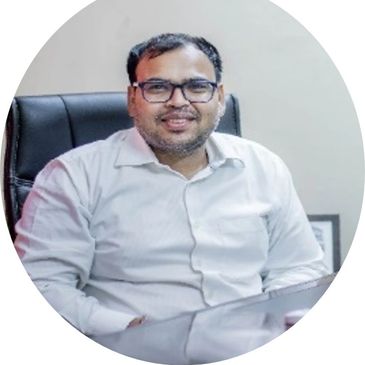 Man in glasses and white shirt sitting on office chair, smiling.