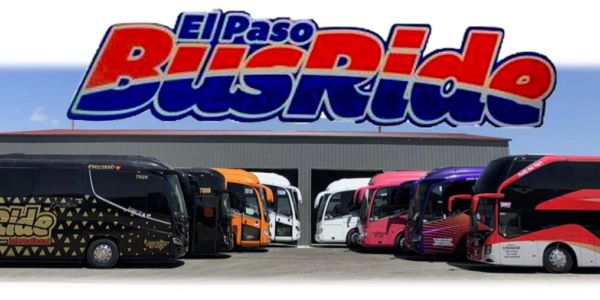 Fleet of colorful El Paso BusRide buses lined up in front of a garage.