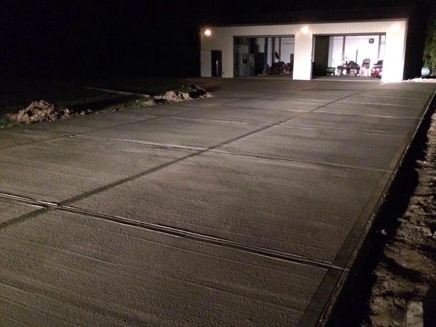 Newly constructed concrete driveway at night.