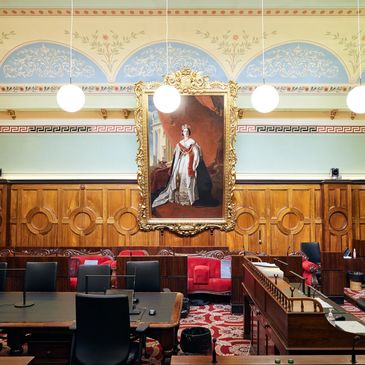 Ornate courtroom with portrait and classic decor.