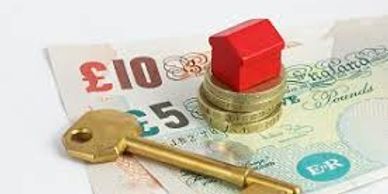 A house model, key, and British currency representing property investment.