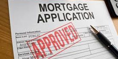 Mortgage application form stamped with APPROVED and a pen beside it.
