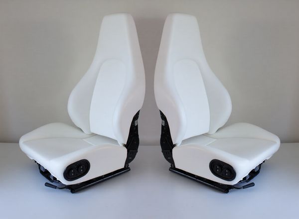 Pair of white car seats with controls.