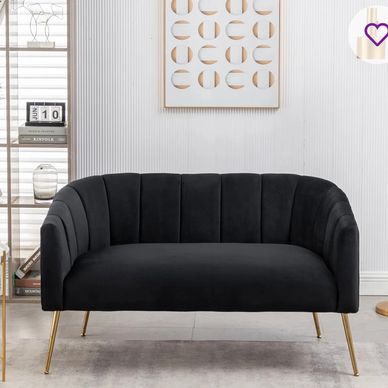 Elegant black velvet loveseat with gold legs in a modern living room.