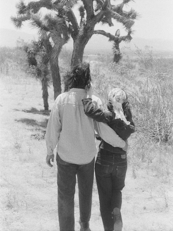 Couple walking in desert landscape, black and white.