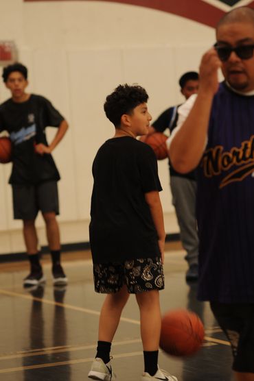 Teenagers playing basketball indoors.
