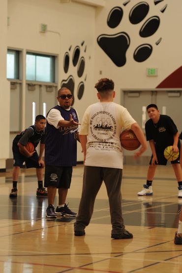 Coach instructing kids during basketball practice.