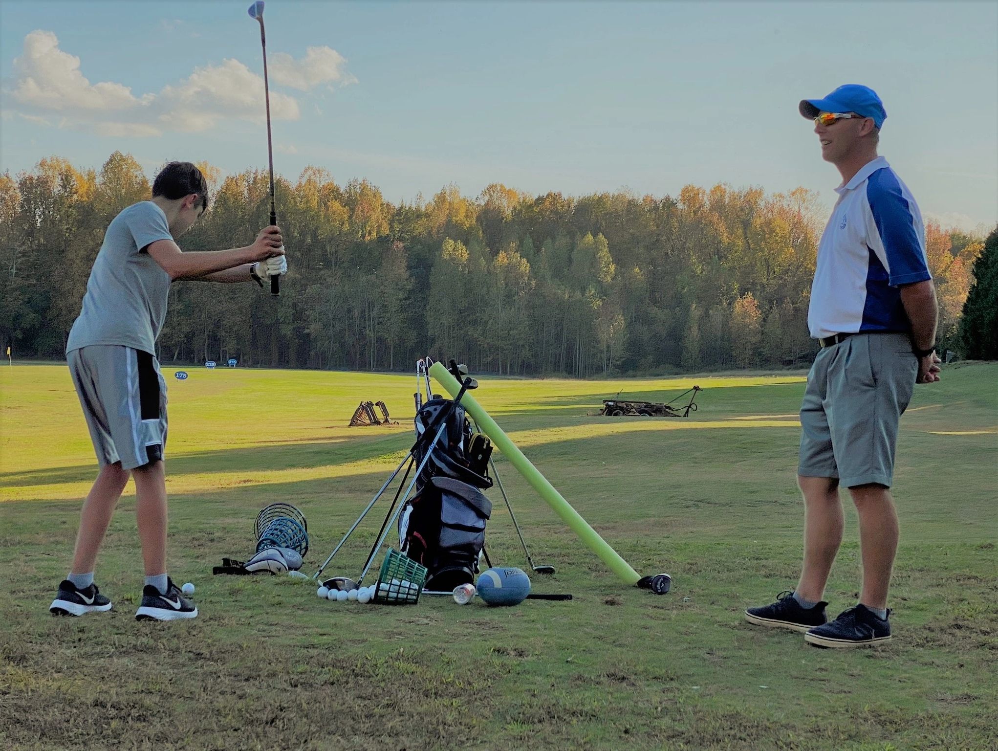 Golf professional watching student.