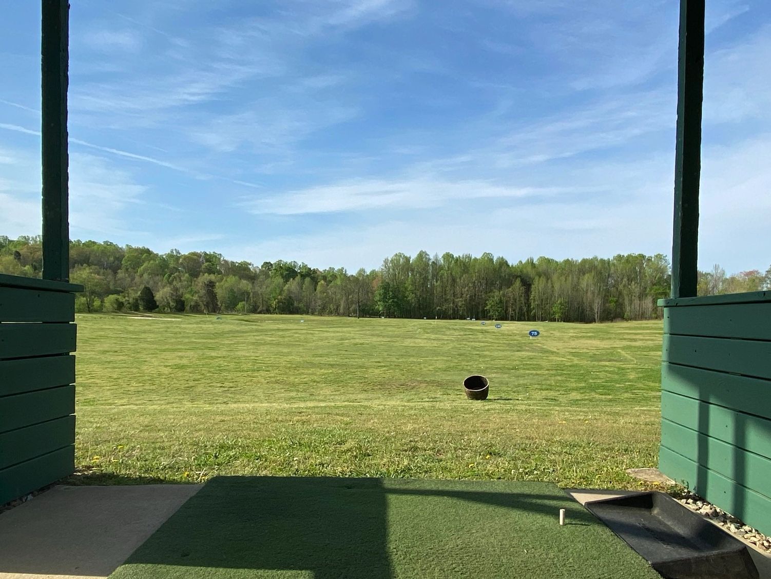 Driving range bay on sunny day.