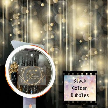 A selfie ring light mirror photo booth in front of a Black backdrop with gold bubbles and sparkles.