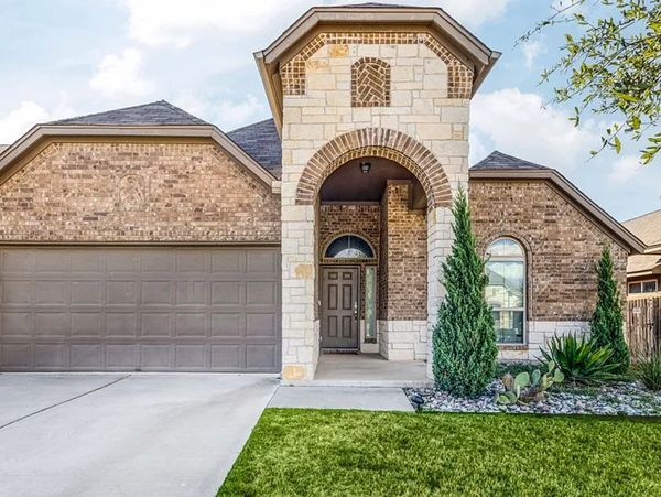 Modern brick house with a two-car garage and arched entryway.