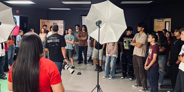 A group of people in a photography studio with lighting equipment.