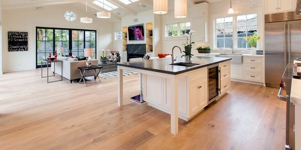 open kitchen and family room showing white oak plank floors walls are white with modern lights