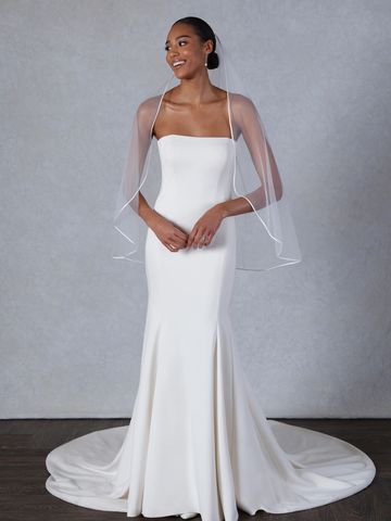 Woman in elegant white wedding dress and veil.