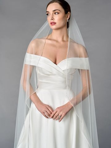 Bride in an elegant off-shoulder white wedding dress with a veil.